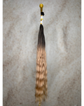 Four bundles of golden blond with deep dark roots body wavy bulk hair arranged together.