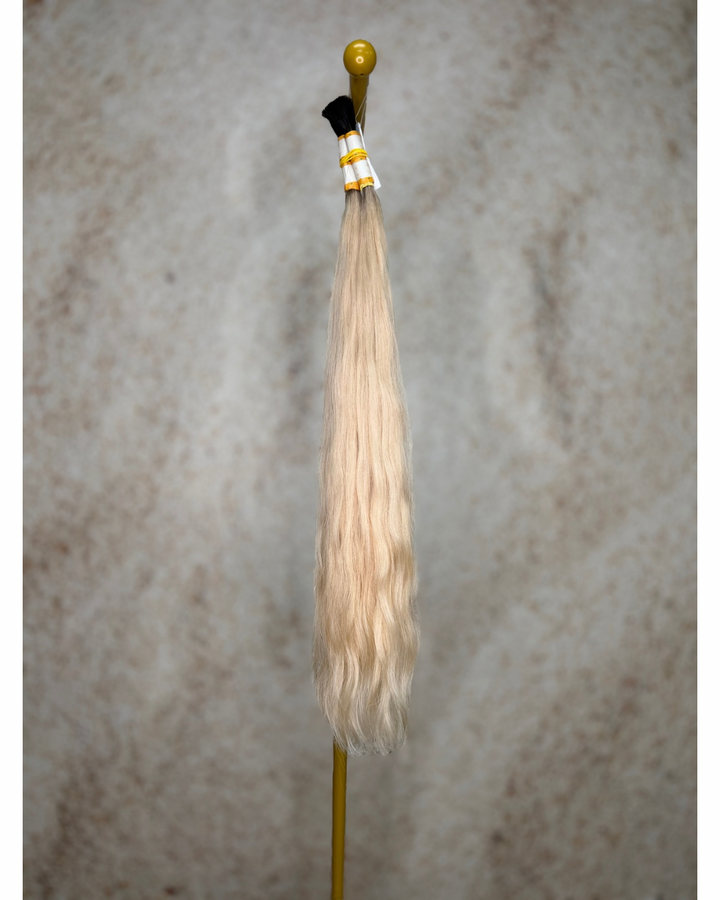 Four bundles of medium blond with dark roots body wavy bulk hair arranged together.